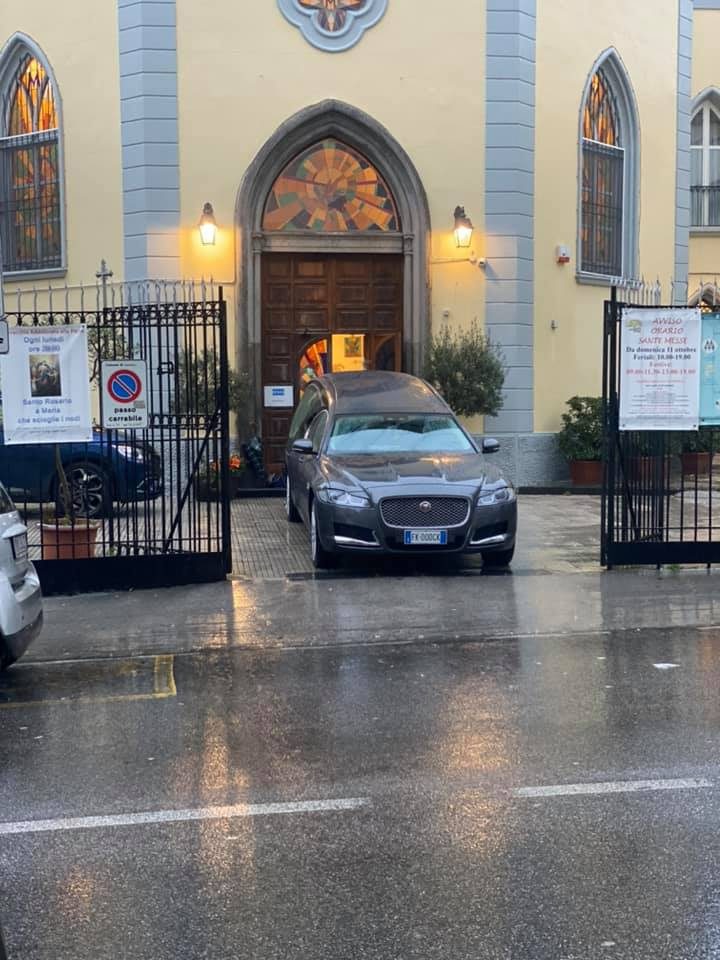 Carro funebre Gennaro Tammaro davanti a una chiesa, giorno di pioggia